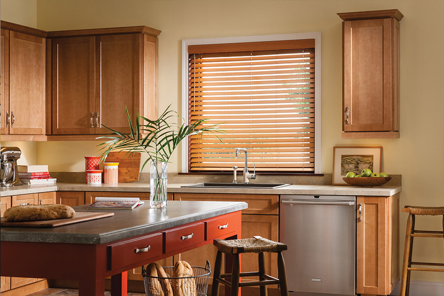 Waterproof faux wood blinds are durable and give you privacy and light control in your Philadelphia kitchen. Dark faux wood blinds above a kitchen sink
